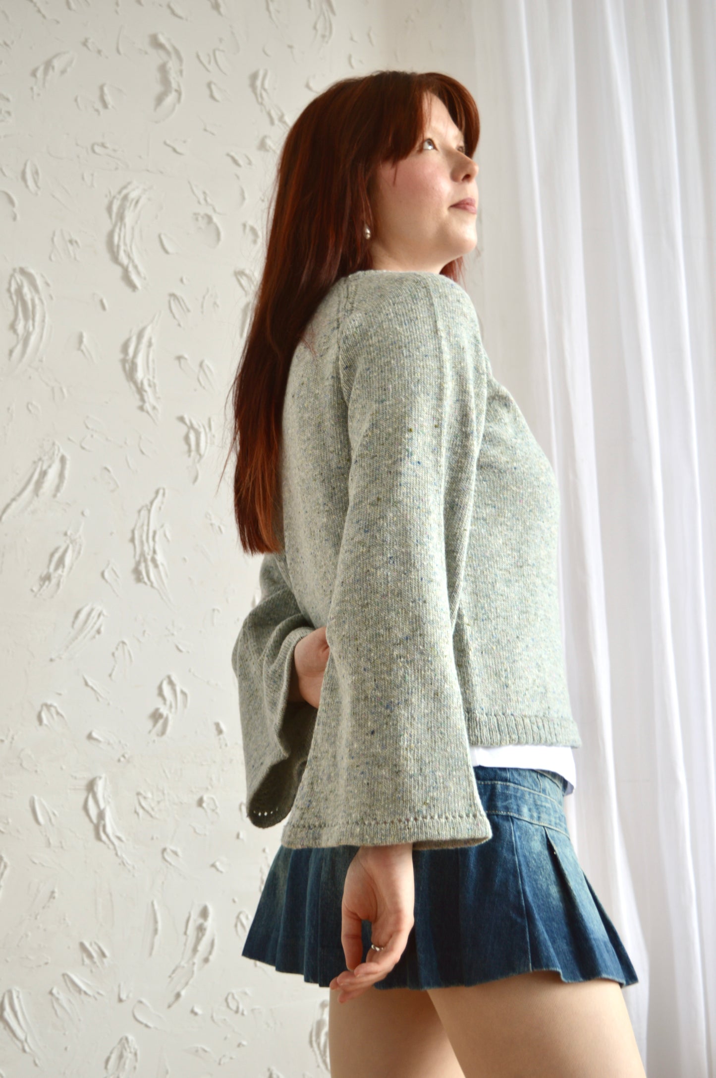 The Bell Sweater in light grey at a side angle