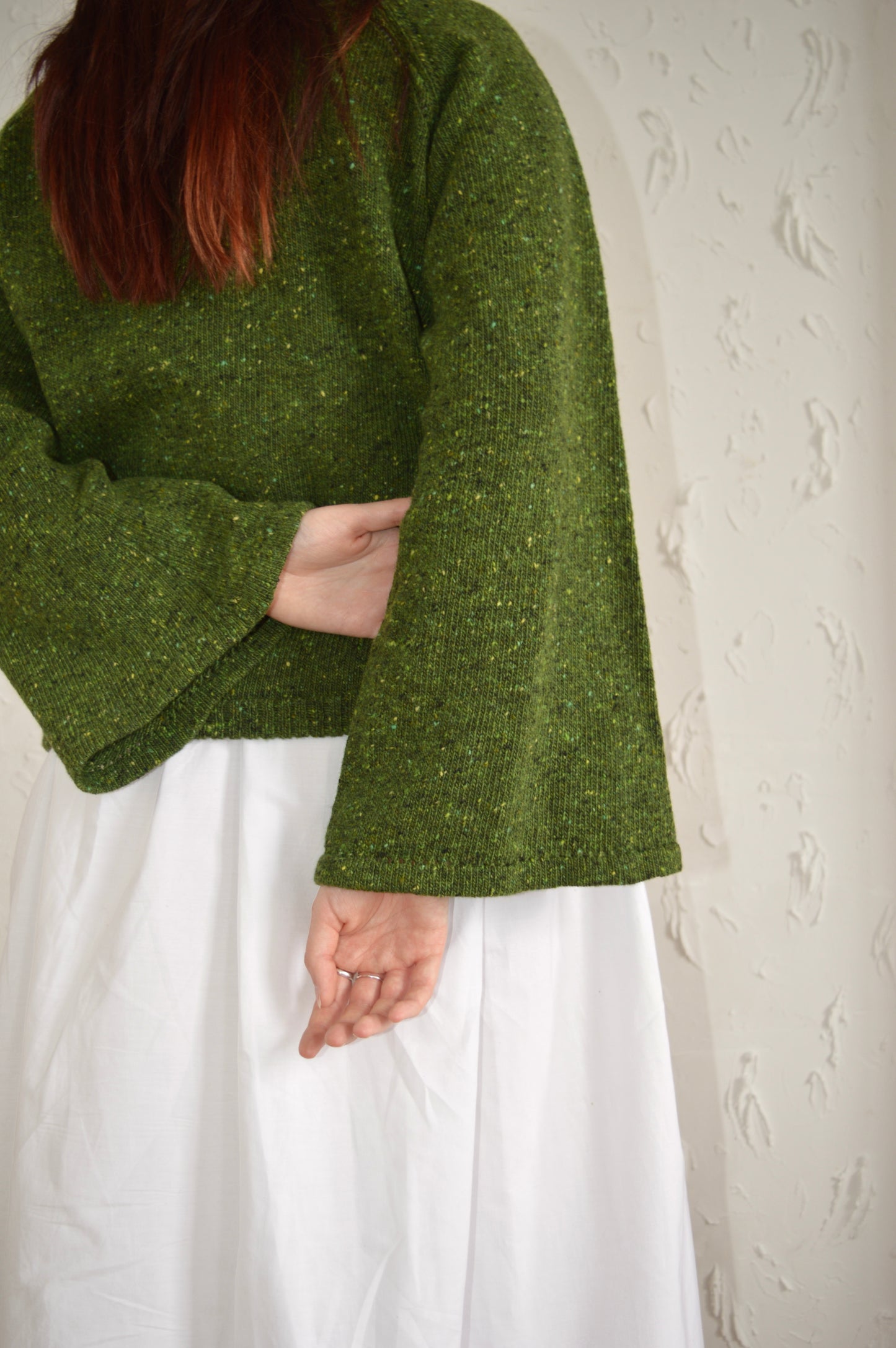 Back view of The Bell Sweater in green, close up of the sleeves
