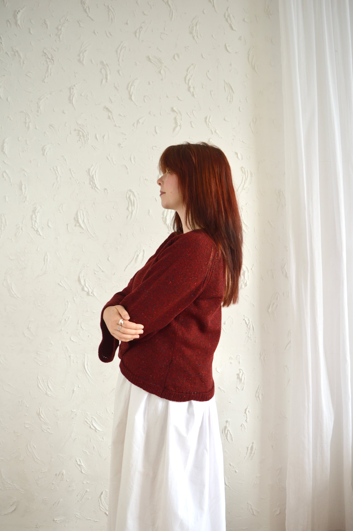 Side view of The Bell Sweater in red