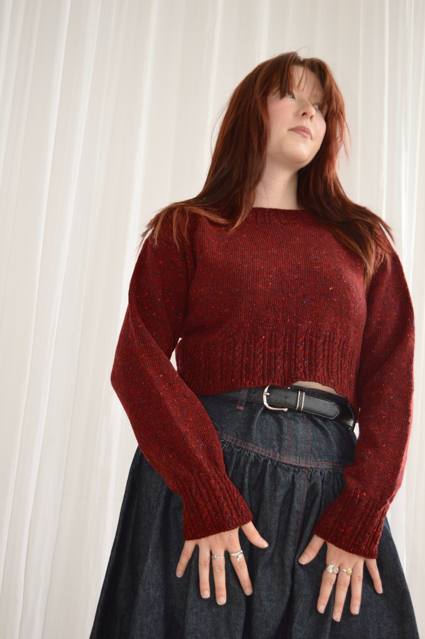 Low angle of model wearing The Cable Sweater in red
