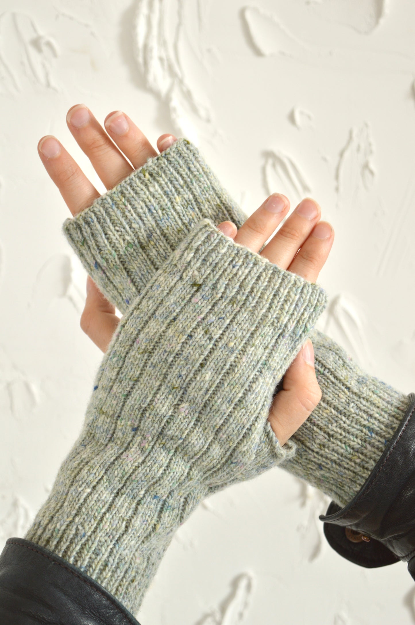 Two hands showcasing The Fingerless Gloves in light grey, one hand resting on top of the other.