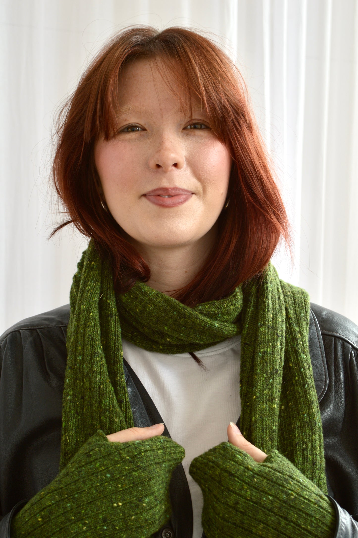 Face-on view of model wearing The Reversible Rib Scarf and Fingerless Gloves in green
