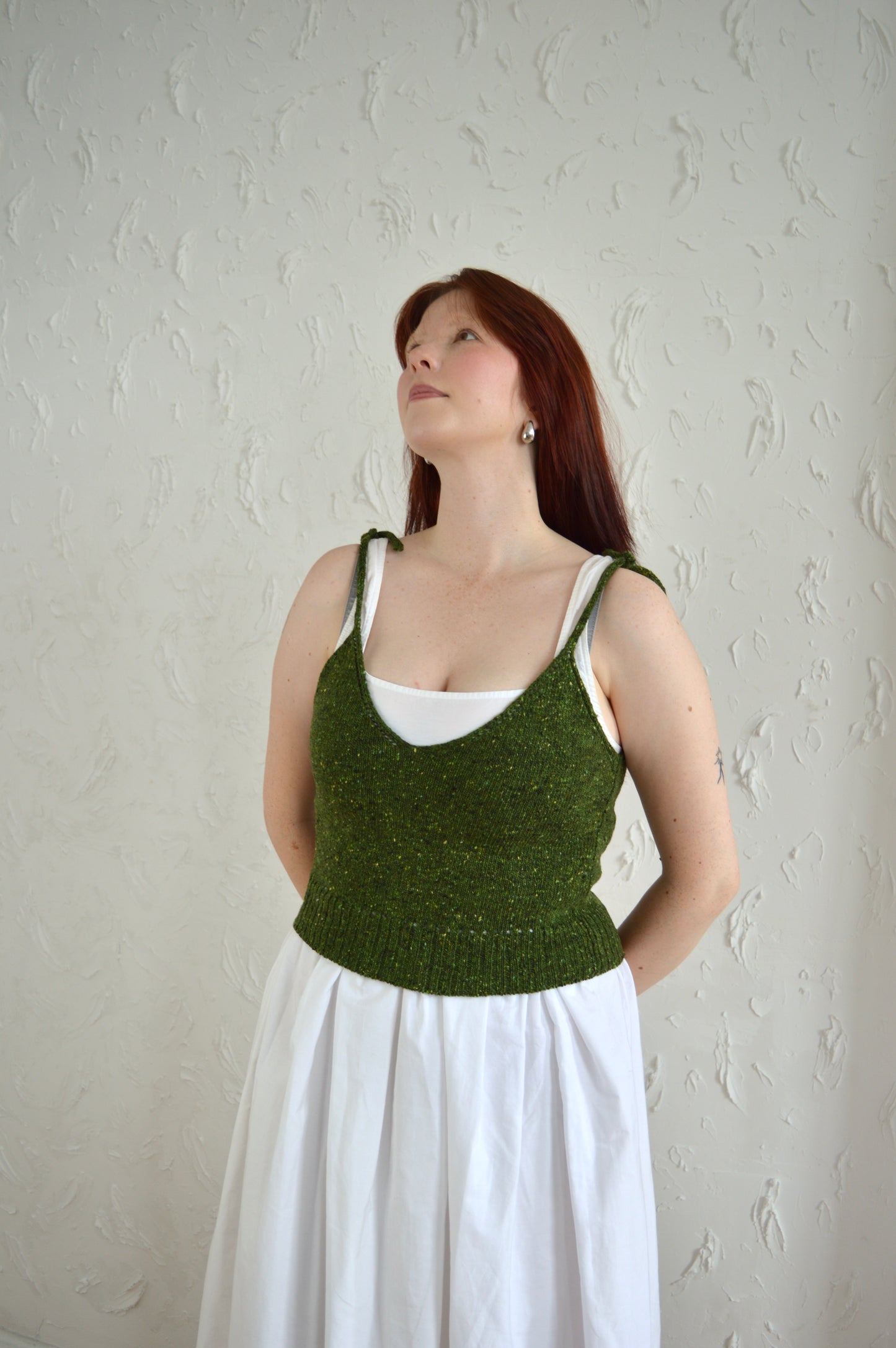 Model wearing the Tie Cami in green, styled with a white dress