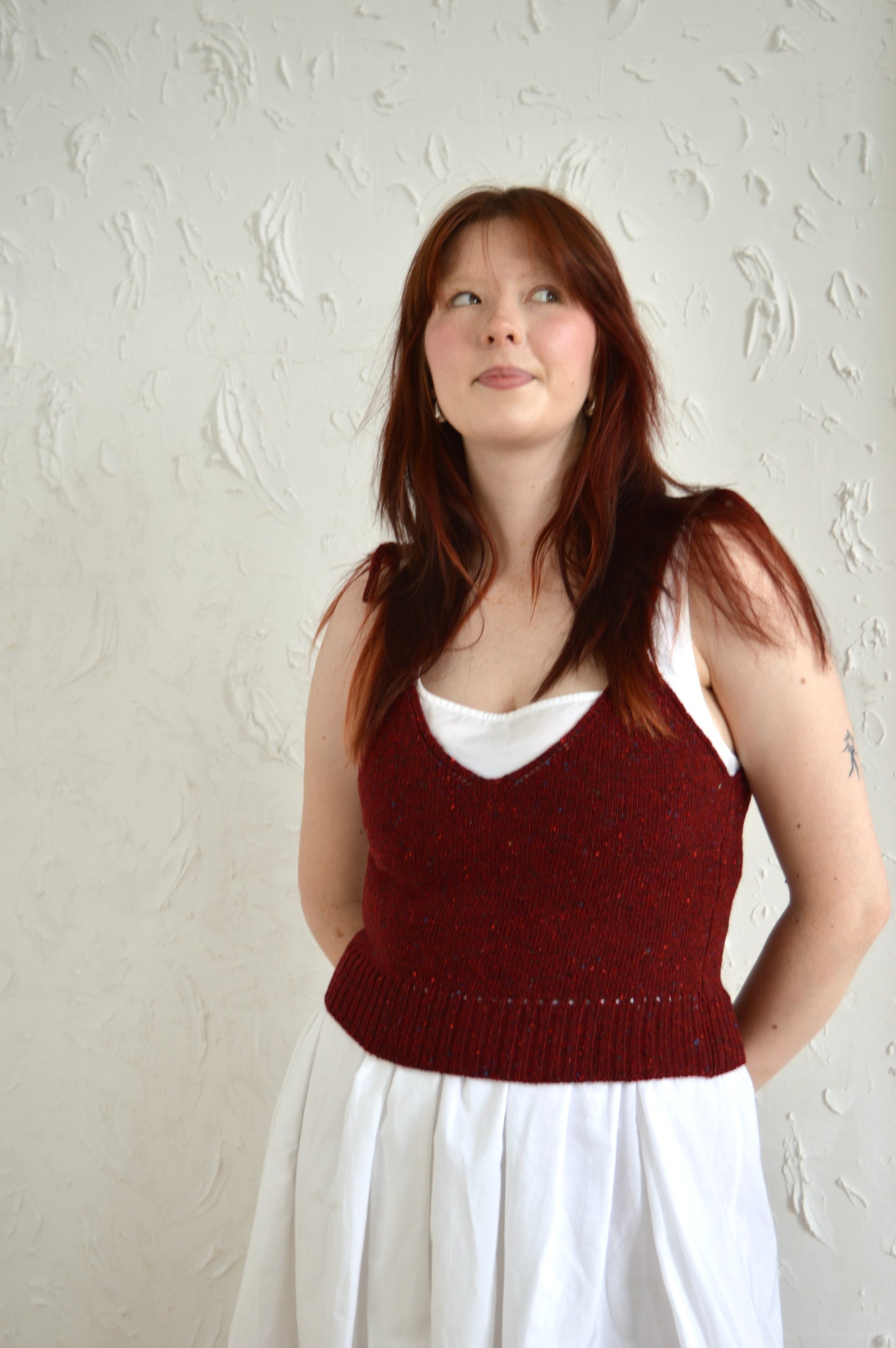Model wears The Tie Cami in red, with hands behind back