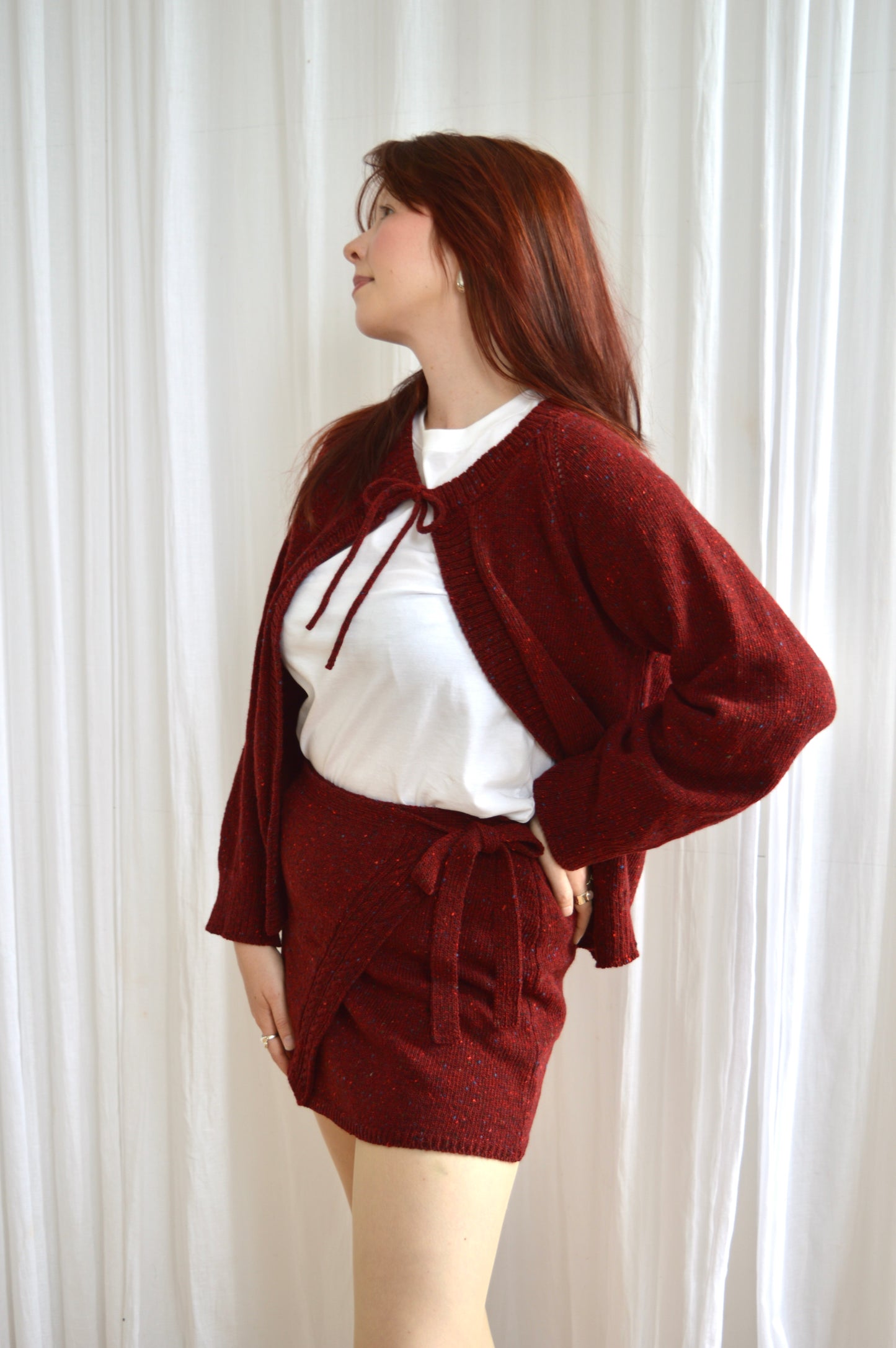 Side view of The Wrap skirt in red, styled with The Tie cami in red and a white Tshirt
