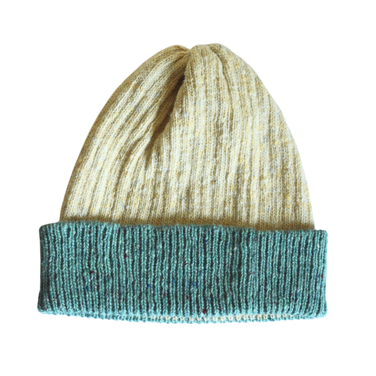 Knitted beanie with cream top and blue band on a white background
