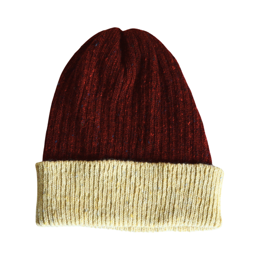 Knitted beanie with red top and cream bottom on a white background