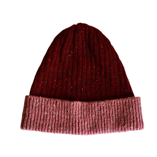 Knitted beanie with two-tone red and pink design on a white background