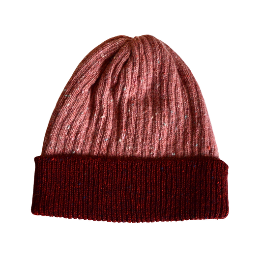 Knitted beanie with two-tone red and pink design on a white background