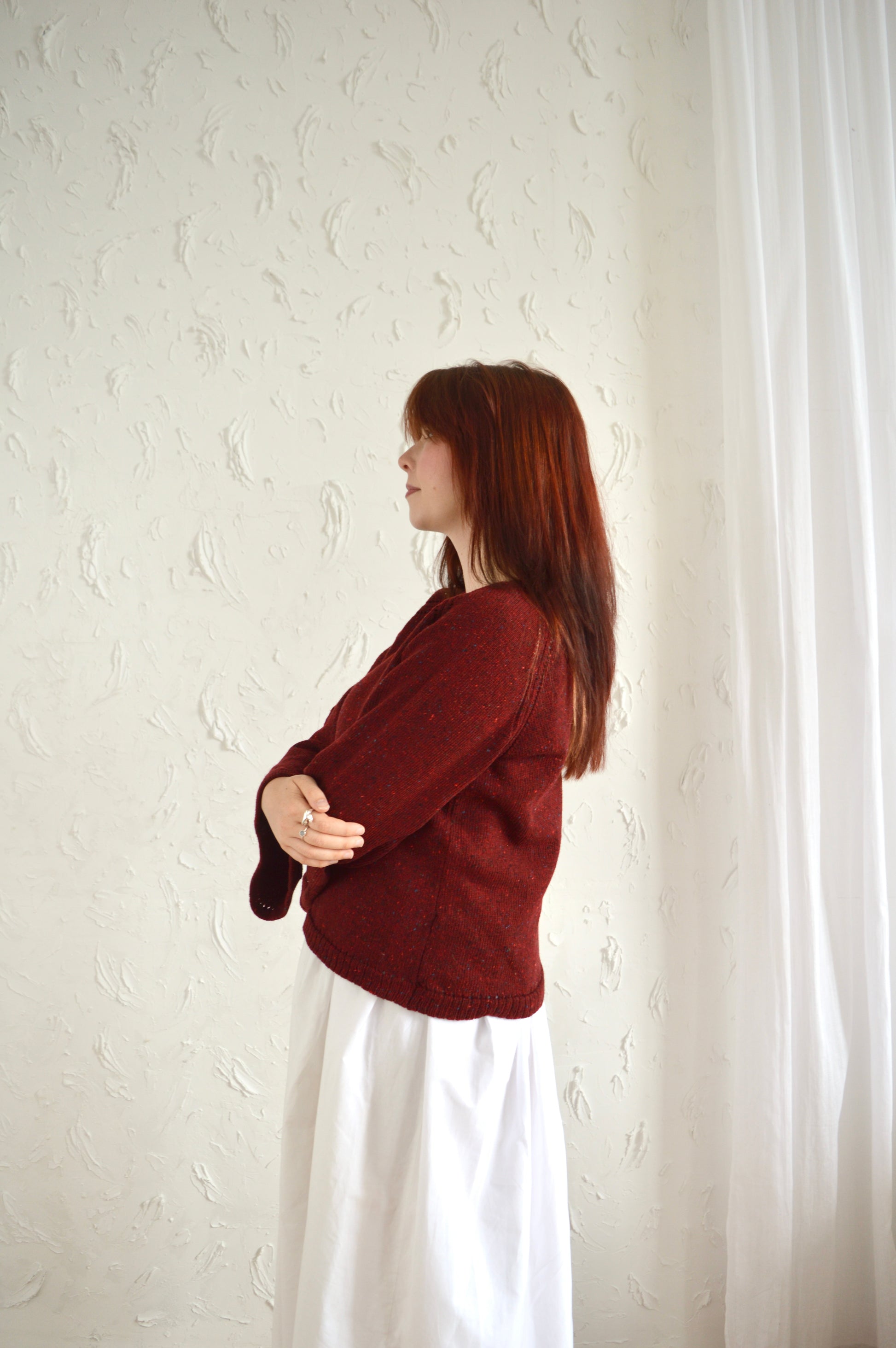 Side view of The Bell Sweater in red