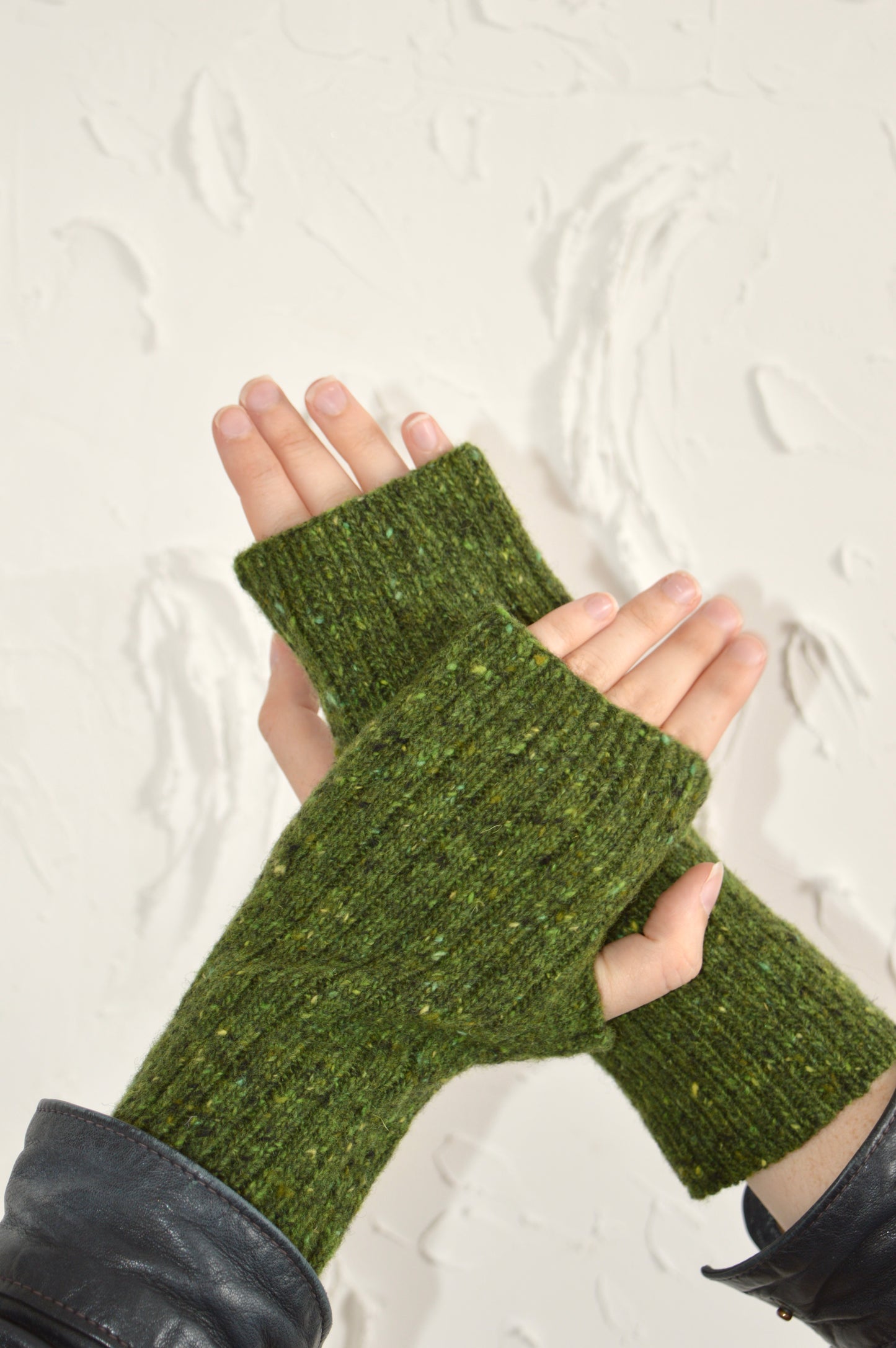 Two hands showcasing The Fingerless Gloves, one hand resting on top of the other.