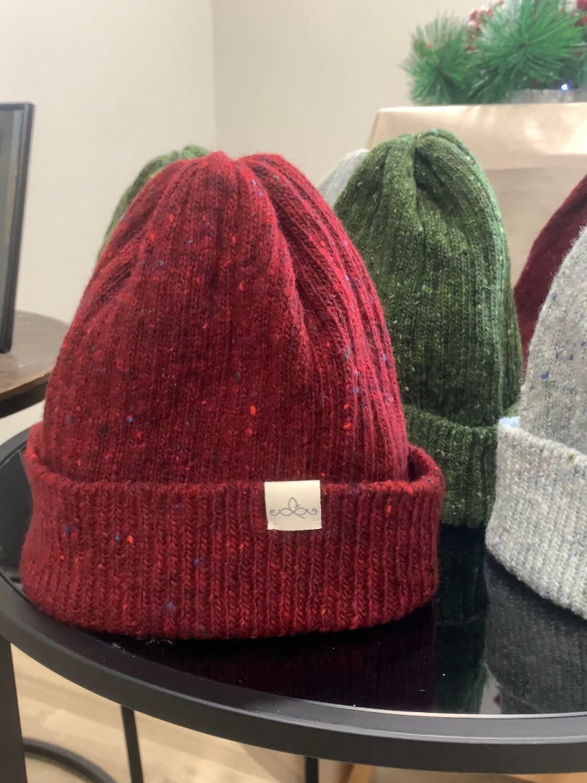 The fitted beanies in red, green and light grey sitting up on a table